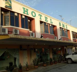 a hotel with a car parked in front of it at Hotel SMZ Sungai Siput (u) in Kampong Rimba Panjang