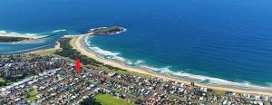 an aerial view of a beach and the ocean at Warilla Sands in Lake Illawarra