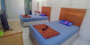 Un pat sau paturi într-o cameră la Hotel Rajawali Mitra RedDoorz