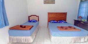 Un pat sau paturi într-o cameră la Hotel Rajawali Mitra RedDoorz