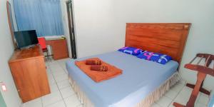 Un pat sau paturi într-o cameră la Hotel Rajawali Mitra RedDoorz