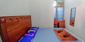 Un pat sau paturi într-o cameră la Hotel Rajawali Mitra RedDoorz