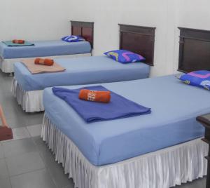 Un pat sau paturi într-o cameră la Hotel Rajawali Mitra RedDoorz
