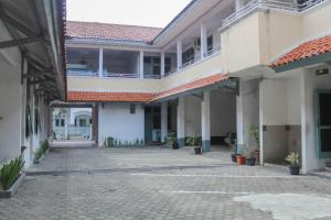 un cortile vuoto di un condominio con un edificio di Hotel Rajawali Mitra RedDoorz a Cirebon