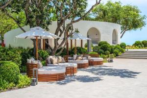 a group of chairs and umbrellas in a courtyard at VALA Hua Hin - Nu Chapter Hotels in Cha Am