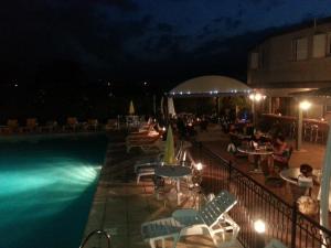 a swimming pool at night with chairs and tables at Casa Marana by Le Lido in Lucciana