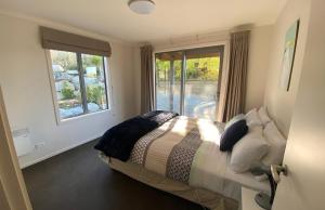 a bedroom with a bed and a window at Ribbonwood Cottage in Lake Tekapo