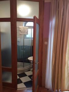 a bathroom with a toilet and a glass door at Vila Madams in Palić
