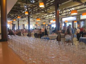 a long row of wine glasses in a room with people at Hotel Restaurante El Lago in Arcos de la Frontera