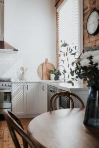 a kitchen with a table and a clock on the wall at Apartments on Belmore - The Ledger in Yarrawonga