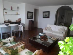 sala de estar con sofá blanco y mesa en COPACABANA VISTA MAR COBERTURA 2 ANDARES DE FRENTE PARA OS FOGOS DO RÉVEILLON COM 5 QUARTOS, 5 AR-CONDICIONADOS, 6 BANHEIROS e GARAGEM GRATUITA, en Río de Janeiro