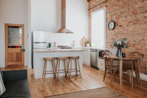 ヤラウォンガにあるApartments on Belmore - The Ledgerのレンガの壁、テーブルと椅子付きのキッチンが備わります。 +14枚の写真