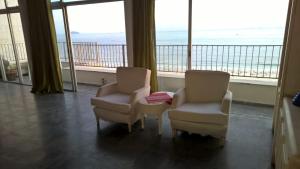 2 sillas en una habitación con vistas al océano en COPACABANA VISTA MAR COBERTURA 2 ANDARES DE FRENTE PARA OS FOGOS DO RÉVEILLON COM 5 QUARTOS, 5 AR-CONDICIONADOS, 6 BANHEIROS e GARAGEM GRATUITA, en Río de Janeiro