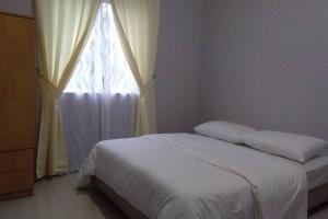 sypialnia z białym łóżkiem i oknem w obiekcie Meru Homestay suitable for up to 7 people w mieście Kelang