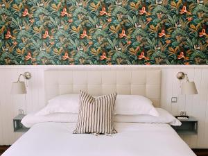 1 dormitorio con 1 cama y papel pintado con motivos florales en Boutike Guesthouse, en Sevilla