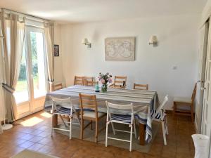 een eetkamer met een blauwe tafel en stoelen bij Les Avocettes in Piriac-sur-Mer