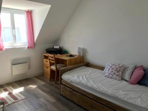 een kleine slaapkamer met een bed en een bureau bij Les Avocettes in Piriac-sur-Mer