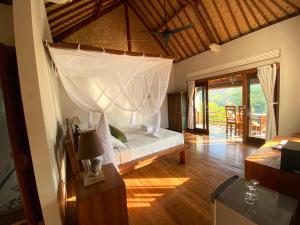 a bedroom with a bed with a canopy at Abian Ayu Villa in Sidemen
