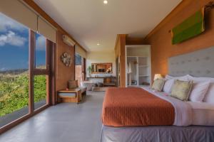 a bedroom with a large bed and large windows at Seven Havens Residence in Selong Belanak