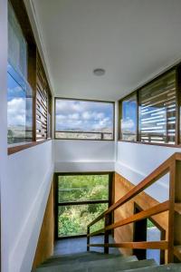 a staircase in a house with large windows at Seven Havens Residence in Selong Belanak