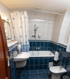 a bathroom with a sink and a tub and a toilet at Reikartz Aurora Kryvyi Rih in Kryvyi Rih