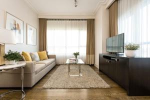 a living room filled with furniture and a tv at Aruga Apartments by Rockwell Makati -Staycation Approved in Manila