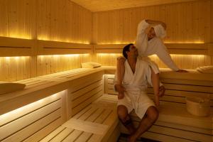 un hombre y una mujer sentados en una sauna en Coco-mat Athens BC en Atenas