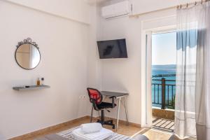 a room with a desk and a view of the ocean at Sitia Old Port Apartment in Sitia