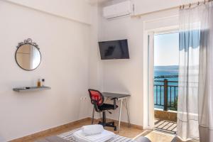 Pokój z biurkiem i widokiem na ocean w obiekcie Sitia Old Port Apartment w mieście Sitia