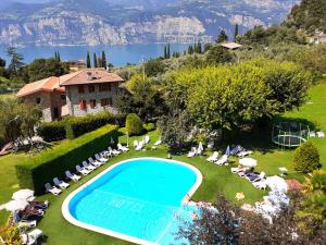 uma vista exterior de uma villa com uma piscina e cadeiras e uma casa em Residence Val Di Monte em Malcesine