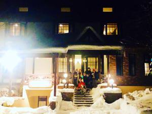 八幡平市安比美丽人生宾馆的一群人站在房子外的雪中