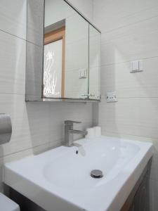 a white bathroom with a sink and a mirror at Tancor Residential Suites in Cebu City
