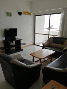 uma sala de estar com sofás e uma mesa de centro em Sri Sayang Resort Service Apartment em Batu Ferringhi