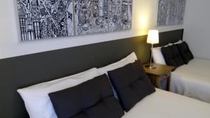 
a hotel room with two beds and a lamp at Hostal El Ninot in Barcelona
