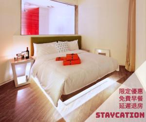 a bedroom with a large white bed and a window at Hotel 7 Taichung in Taichung