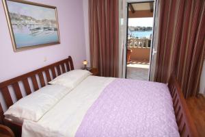 1 dormitorio con cama y vistas a un balcón en Villa Sun, en Seget Vranjica