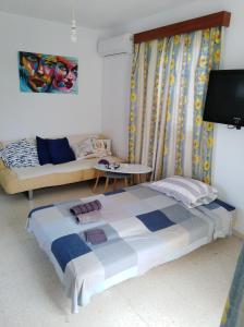 - une chambre avec un lit et un canapé dans l'établissement Larnaca, Pervolia 1 bedroom seaside apartment, à Perivólia