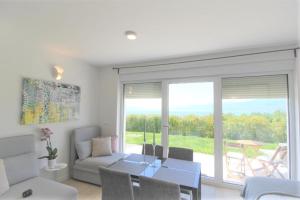 ein Wohnzimmer mit einer Couch und einem Tisch mit Stühlen in der Unterkunft Studio apartment Miramare in Rijeka