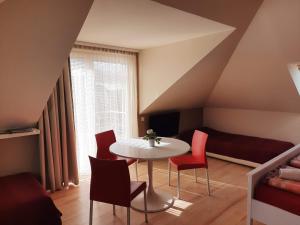 ギェネシュディアーシュにあるSportházのテーブル、椅子、ベッドが備わる客室です。