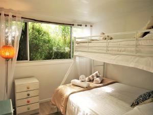een slaapkamer met twee stapelbedden en een raam bij Orchard Cottage - modern Australian Sunshine Coast holiday cottage on organic farm nr beach in Valdora