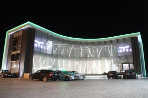a building with cars parked outside of it at night at Albes Hotel in Fier