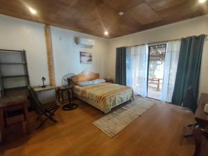 a bedroom with a bed and a large window at Moalboal T Breeze Coastal Resort in Moalboal