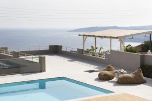 a villa with a swimming pool and a view of the ocean at EtherealVilla in Lourdata