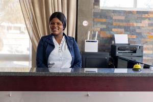 a woman sitting at a counter in an office at Dakota Lodge in Alberton
