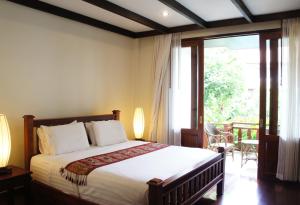 a bedroom with a bed and a large window at Athena Hotel in Pakse