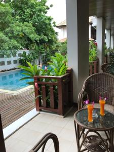 a patio with a table and chairs and a swimming pool at Athena Hotel in Pakse