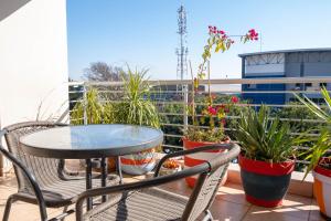 a balcony with a table and chairs and potted plants at Dakota Lodge in Alberton