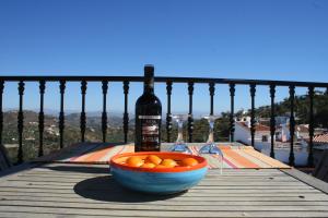a bottle of wine and a bowl of oranges on a table at Casa Sonrisa in Guaro