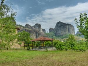 a gazebo in a field with mountains in the background at Hotel Doupiani House in Kalabaka