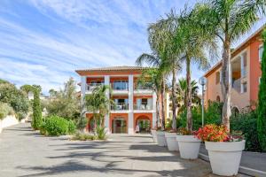 un edificio con palmeras delante en Pierre & Vacances Residence Les Rivages des Issambres, en Les Issambres